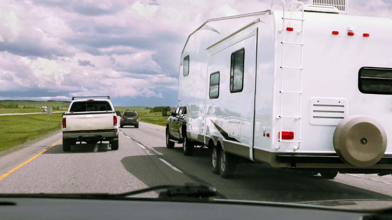 RV being pulled by a truck cruising down the highway