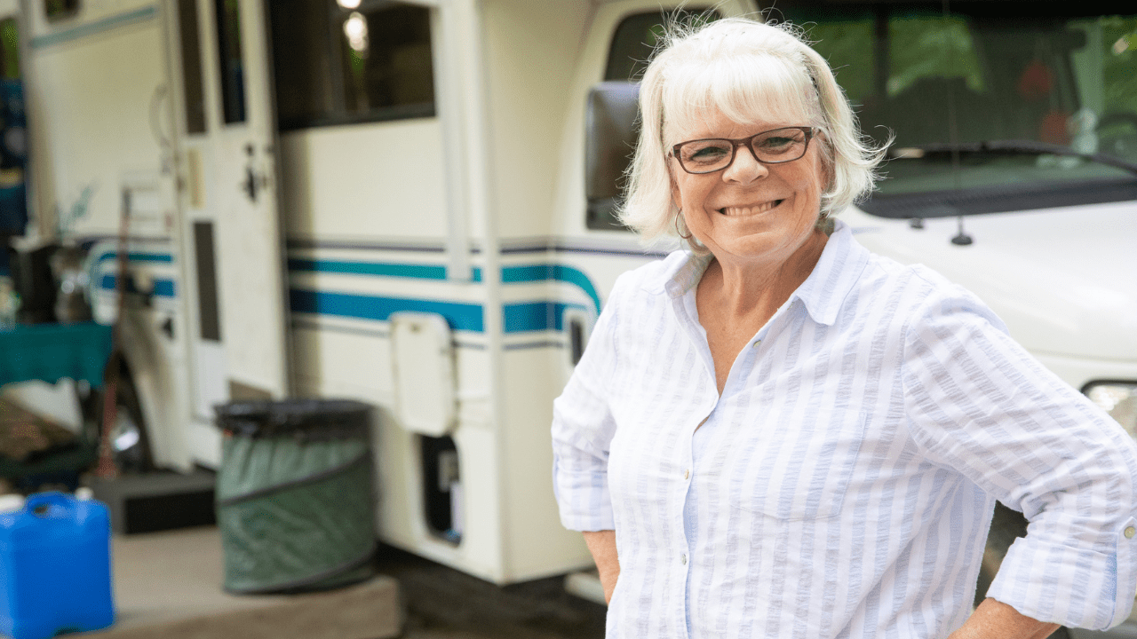 A senior woman standing in front of her RV - © Mathayward