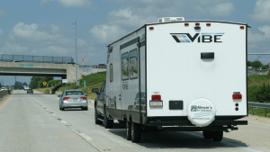 A white Forest River Vibe RV travels down the highway