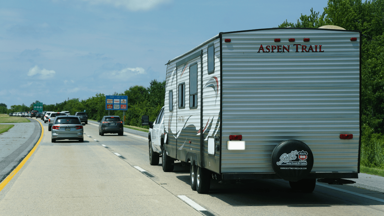 The Aspen Trail camper trailer pulled by a pickup truck
