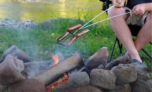 Cooking hotdogs over the campfire