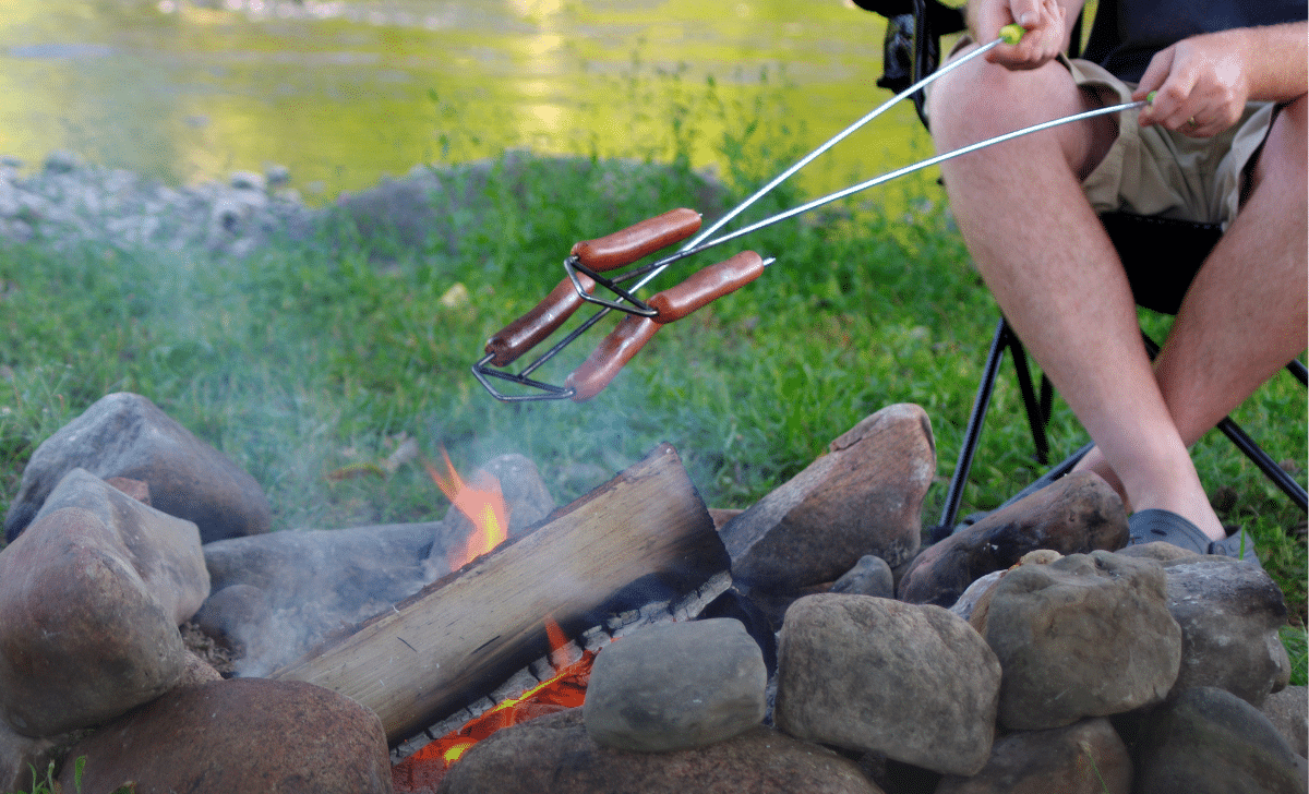 Cooking hotdogs over the campfire