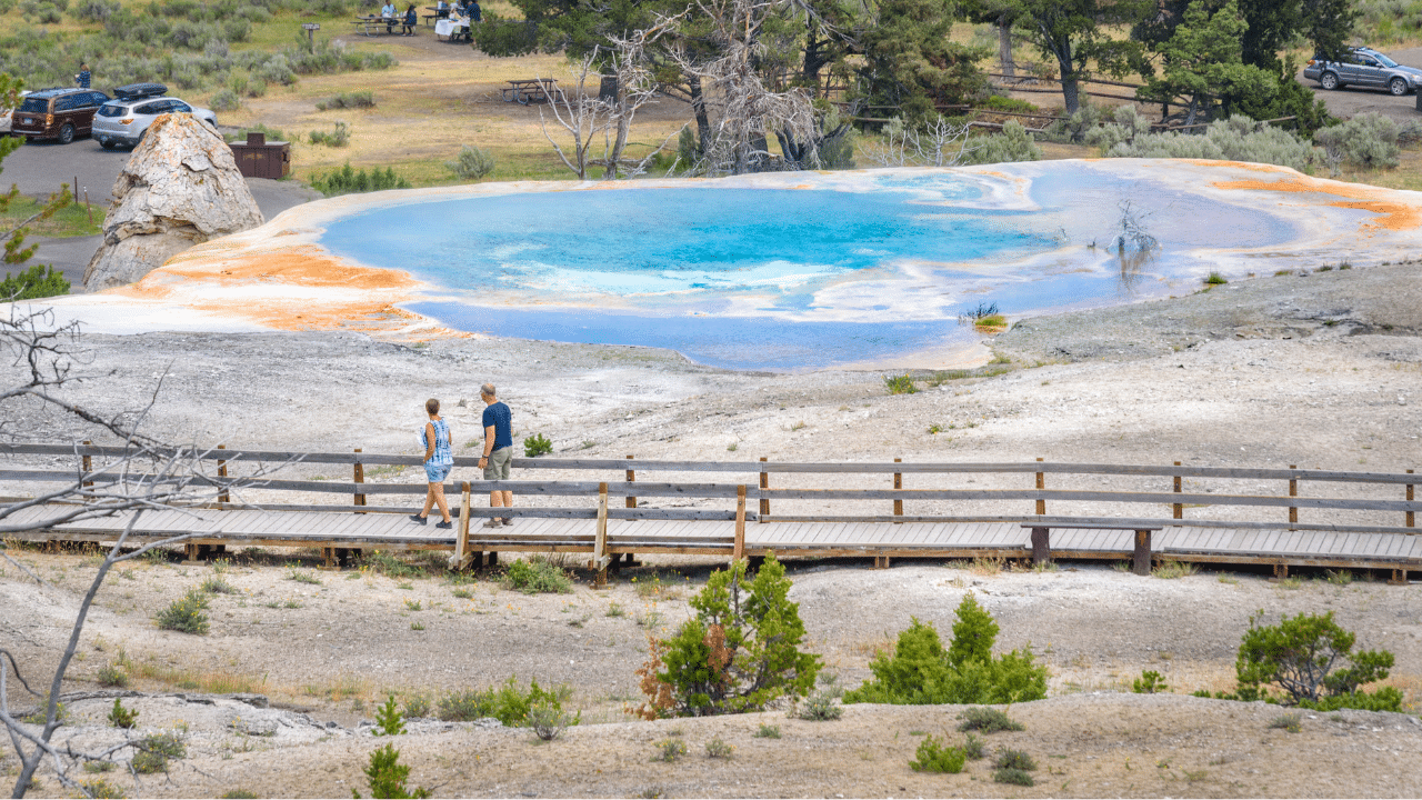 Tourists watching Mound Spring next to Liberty Cap in Mammoth Hot Springs area, Yellowstone Park