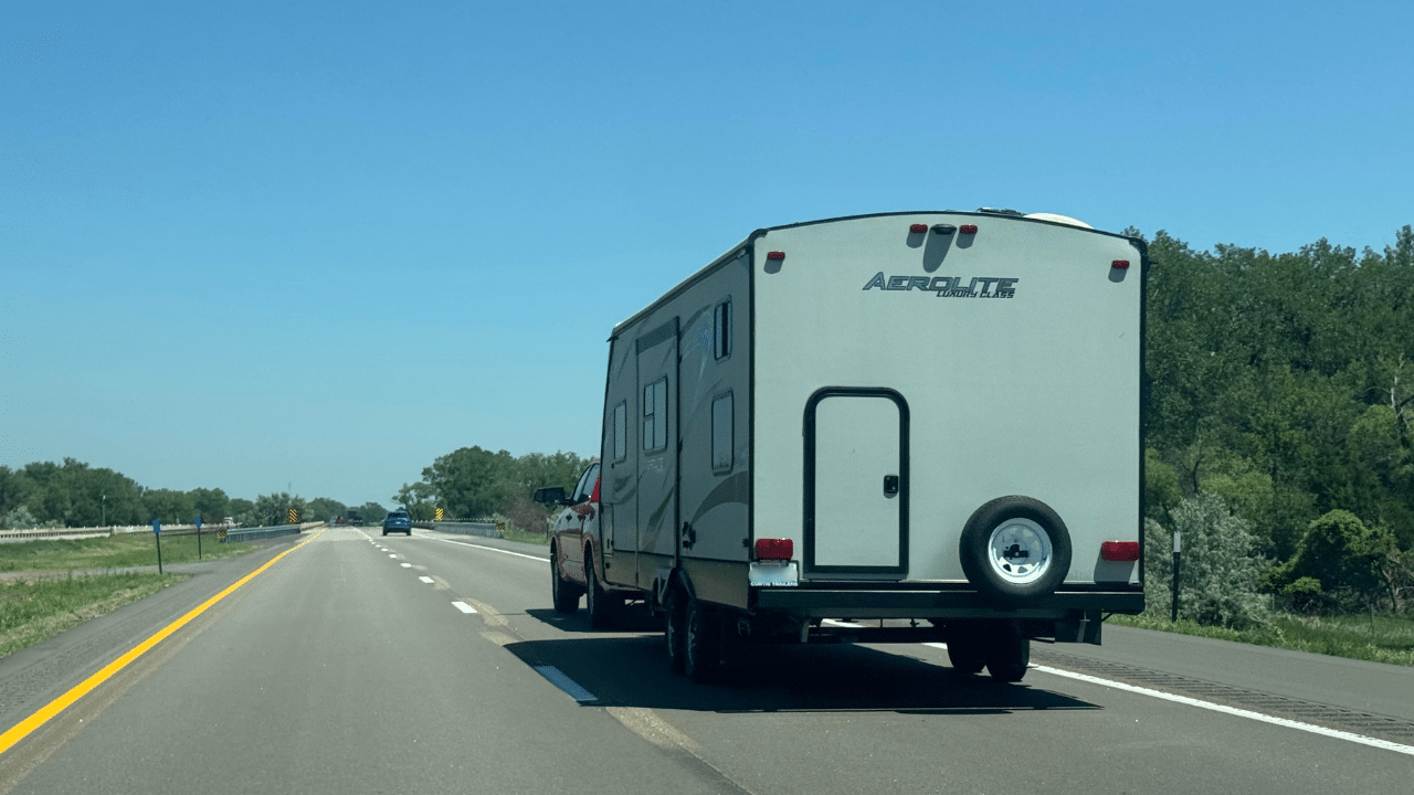 A truck and travel trailer traveling down the highway