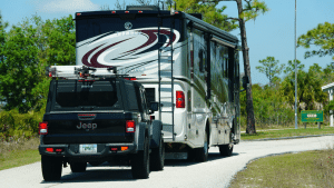 A Tiffin motorhome driving toward the entrance of a campground