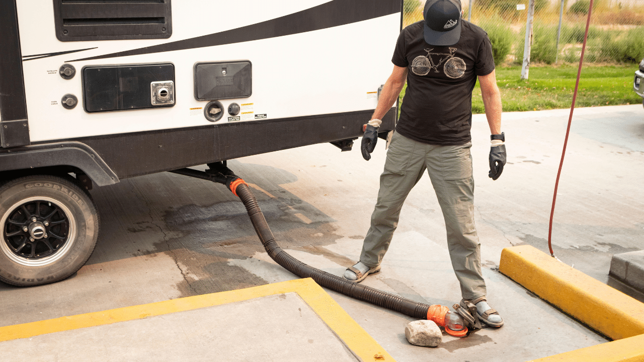 A man dumps RV wastewater at dump station
