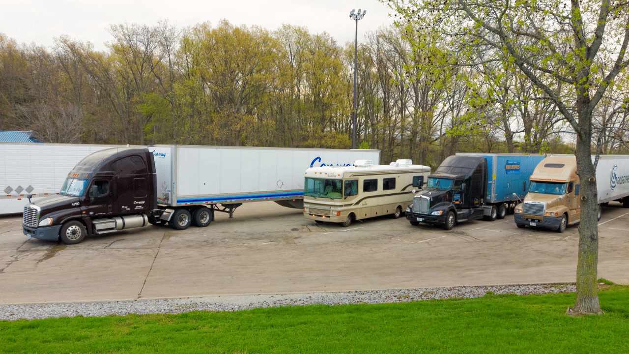 An RV parked alongside Semi Trucks at a Rest Area