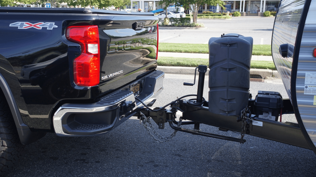 A Chevrolet Silverado 4X4 pickup truck towing travel trailer with hitch assembly