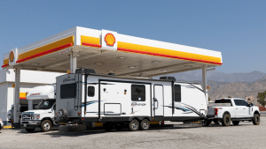 A truck and travel trailer refuel at a Shell station